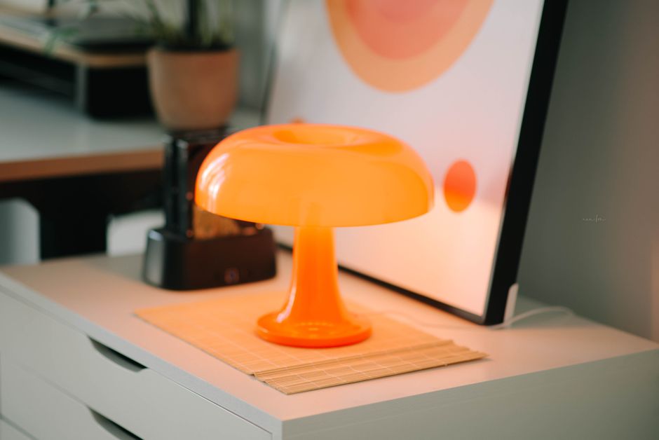 Oranje wanddecoratie in zonnige eetkamer.