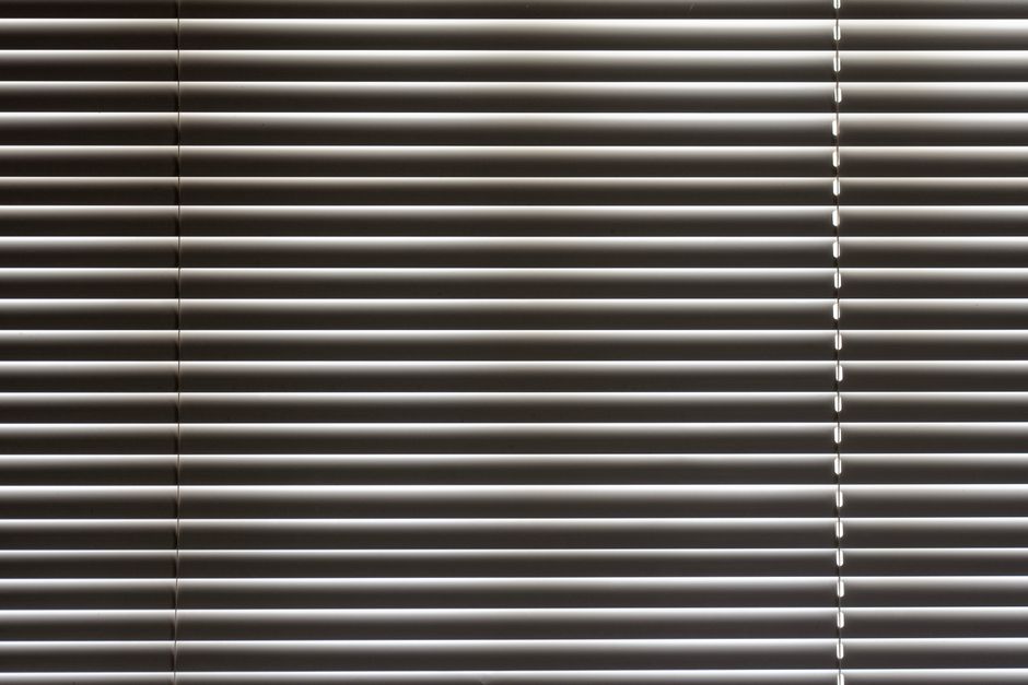 Dynamische metalen zonwering bij minimalistisch raam.